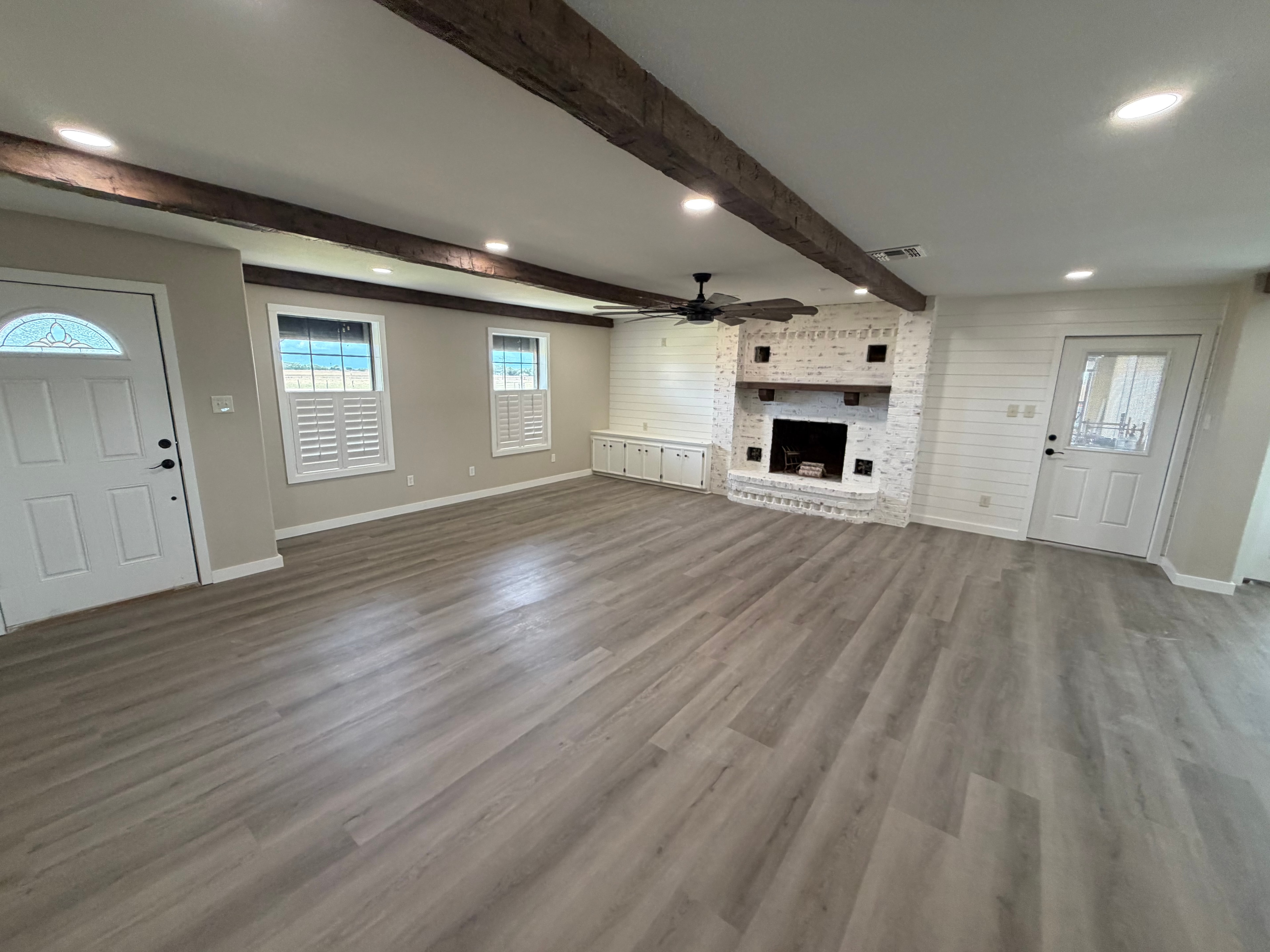 Rustic modern living room renovation with exposed beams and fireplace